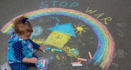 Children draw the Ukrainian flag house on the pavement. Selective focus.