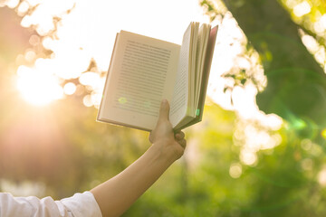 close up of person reading a book outdoors