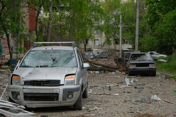 Fototapeta na wymiar Broken cars on the street in Kharkiv after bomb attack by Russian