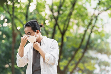 Asian young man is wearing a mask outdoors 