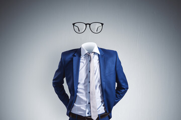 Headless invisible businessman with abstract glasses standing on gray wall background. Business and...