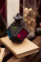 Black lantern in stained glass. Near the book in craft paper.