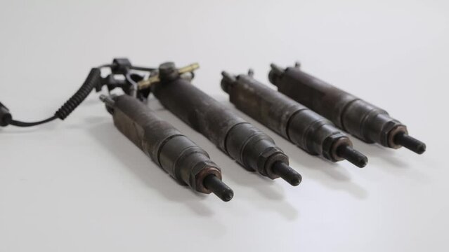 Needles and nozzles on nozzles from a diesel engine. Deterioration of the fuel system of the car, macro. White background