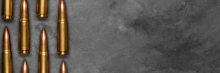 Bullets on gray background banner with copy space. Cartridges 7.62 caliber for Kalashnikov assault...