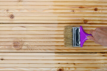 Painting new wooden boards for patio by special waterproof protective oil. View from above. Copy space.