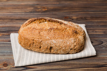 freshly baked bread with napkin on rustic table top view. Healthy white bread loaf isolated