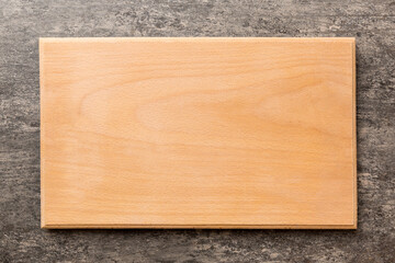 Top view of wooden cutting board on cement background. Empty space for your design