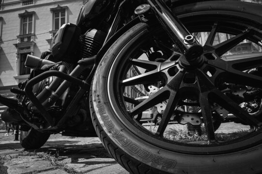 May 29, 2022 Ukraine Lviv, a motorcycle parked on the sidewalk with a blurred city street with cars in the background, selective focus. black and white photo