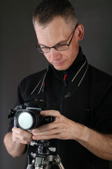 the young man sets a camera on a tripod