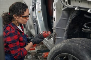 Female auto mechanic repairing car at repair service station