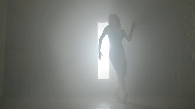 Woman dancing bachata dance indoors with smoke.