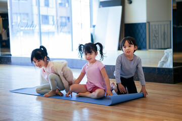ヨガマットの上で遊ぶ幼い子供たち