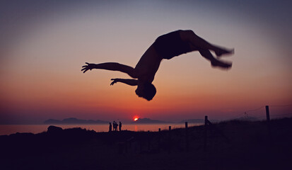 man doing backflip on a sunset background