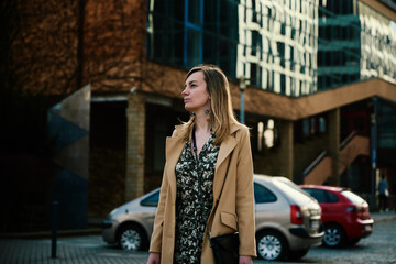 Millennial caucasian woman enjoying with sunny day outdoors, Female tourist wearing stylish trench walking at european city street