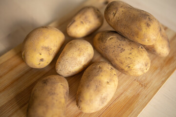 peeled potatoes lie on a wooden table surface, in the kitchen. Potato supply problems, sales restrictions, world hunger
