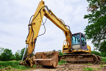 Yellow excavator on construction site, Heavy construction machine excavating soil, Crawler backhoe working at dirt soil