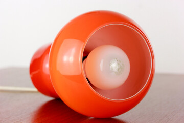 A 60s modern orange bedside lamp with glass spaceage vintage midcentury design front side view...