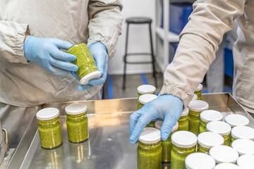 Pesto sauce Industrial process. High quality sauce production. Checking worker at a food factory...