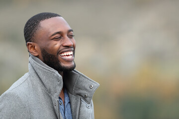 Happy man with black skin laughing in the mountain in winter