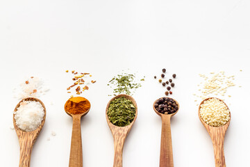 Colorful spices and herbs in wooden spoons. Cooking background