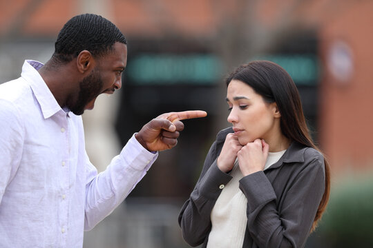 Angry man scolding and accusing to a scared woman