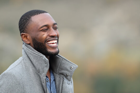 Happy man with black skin laughing in the mountain in winter