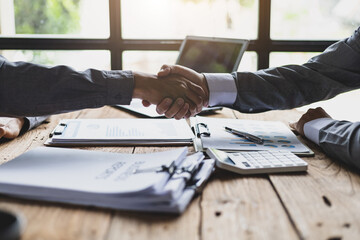 Handshake. Businessman on desk shaking hands with accountant or financial advisor in office.