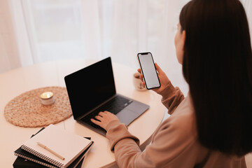 Woman working remotely from her house with a laptop