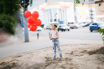 Girl child preteen in jeans and white t-shirt on sidewalk with red balloons, generation Z