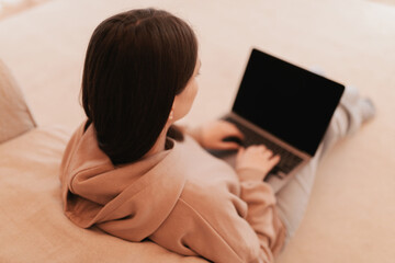 Woman working remotely from her house with a laptop