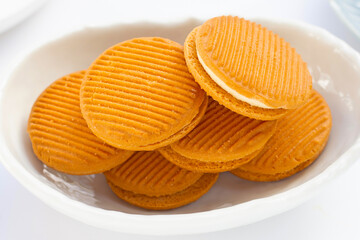 Custard cream sandwich biscuits on white background.