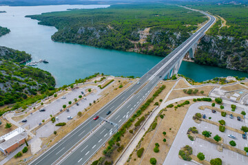 The movement of cars on the bridge over the sea, cars are parked near the highway.