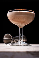 Brandy Alexander cocktail on wooden table and black background