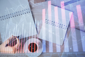 Multi exposure of woman's hands making notes with forex graph hologram. Concept of technical analysis.
