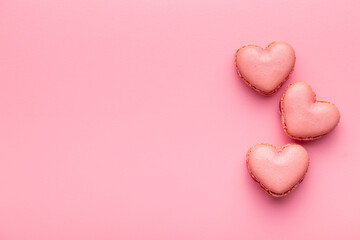 Heart shaped Sweet macarons on pink background.