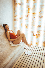 Beautiful young woman relaxing in salt room and enjoying in halotherapy treatment. She wearing...