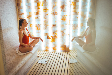 One woman relaxing in salt room and enjoying in halotherapy treatment. Beautiful woman inhales salt air, halotherapy. Salt air treatment at the spa