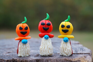 Figures of three dwarfs decorated with a pumpkin. Halloween decorations.