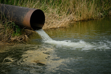 Draining sewage from pipe into river, pollution rivers and ecology. - obrazy, fototapety, plakaty