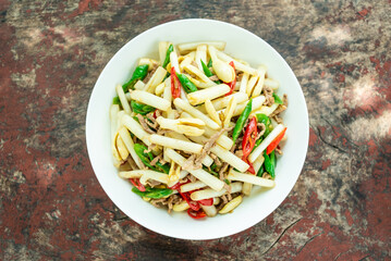 A plate of fried meat with peanut sprouts on a wooden table