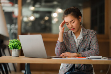 Asian businesswoman uses a calculator to calculate her company's financial results and budget....