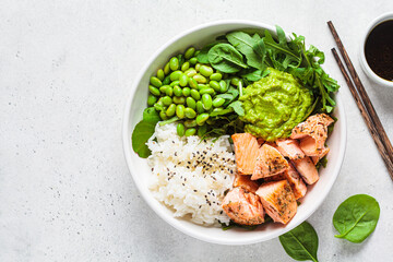 Fried salmon salad with rice, edamame and guacamole. Healthy diet recipe concept.