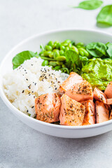 Fried salmon salad with rice, edamame and guacamole. Healthy diet recipe concept.