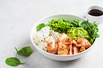 Fried salmon salad with rice, edamame and guacamole. Healthy diet recipe concept.