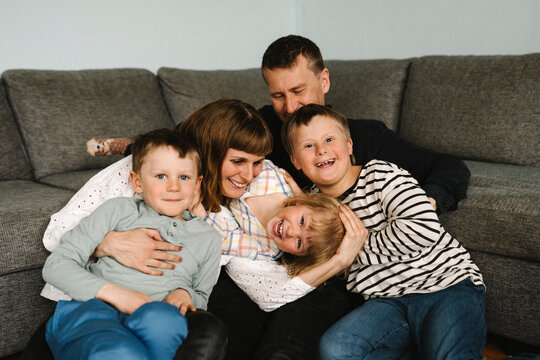 Portrait of happy children with parents against sofa in living room