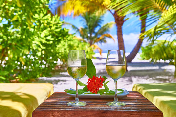 White wine in glasses near deck chair. Maldives beach resort. Amazing view, blue turquoise lagoon...
