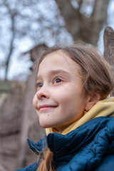 Portrait of little cute girl  who admire pensive the autumn nature. Child in yellow hoody and navy blue jacket 