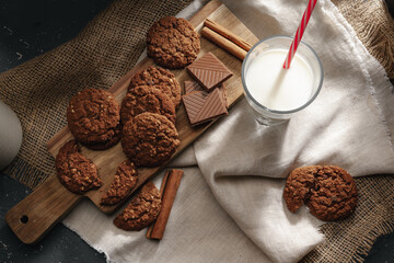 Top view of milk bottle with cookies on wooden board