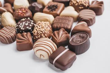 Assortment of dark, white and milk chocolate on white background