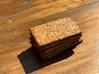 Stacks of the crunchy crisp bread biscuits with granulated sugar on the wood table with closeup shot